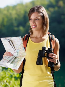 woman hiking with binoculars and map
