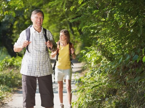 grandfather and grandaughter hiking in wood