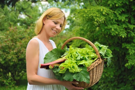 Young woman holding basket with vegetable