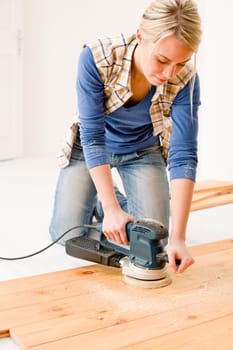 Home improvement - handywoman sanding wooden floor