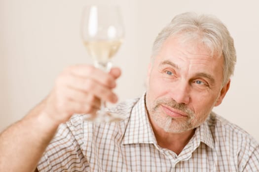 Senior mature man with glass of white wine