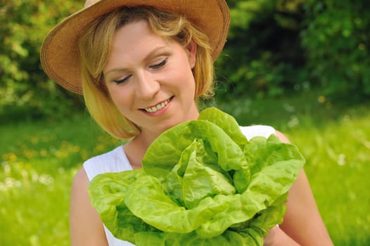 Young woman holding fresh lettuce