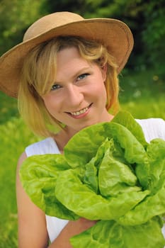 Young woman holding fresh lettuce