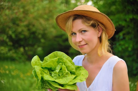 Young woman holding fresh lettuce