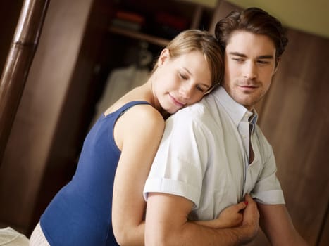 young heterosexual couple hugging on bed