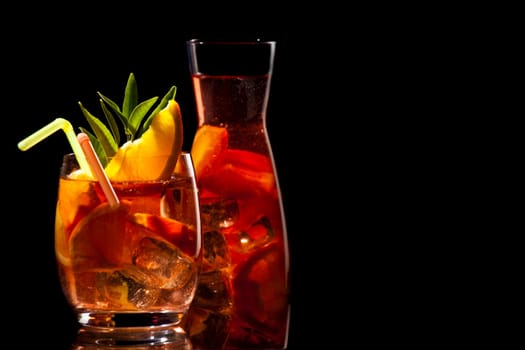 Iced tea in a glass with straw,orange and ice cubes