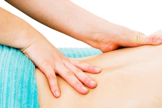 A female receives a lower back massage at a day spa.