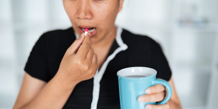 Close up woman holding pill in hand with water feeling sick. female going to take painkiller from headache, painkiller, healthcare, medicine, treatment, therapy, patient, disease illness concept.