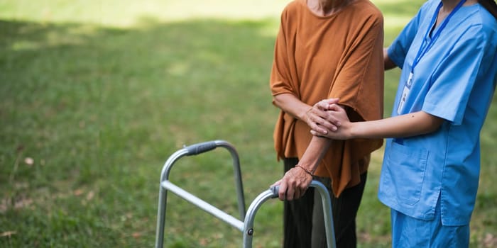 Nurse or caregiver hand on walking frame for support, help or trust moving leg in rehabilitation. Physiotherapy healthcare, Medical caregiver consulting disabled elderly patient at home.