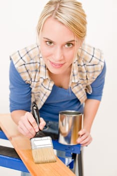 Home improvement - handywoman painting wooden plank