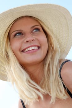 Closeup of beautiful blond woman wearing hat at the beach