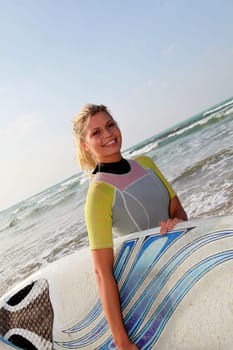 Young woman holding surfboard at the beach