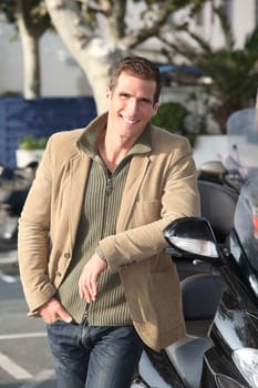 Man standing by motorcycle in town