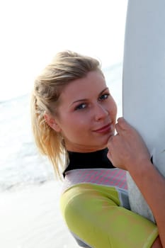 Young woman holding surfboard at the beach