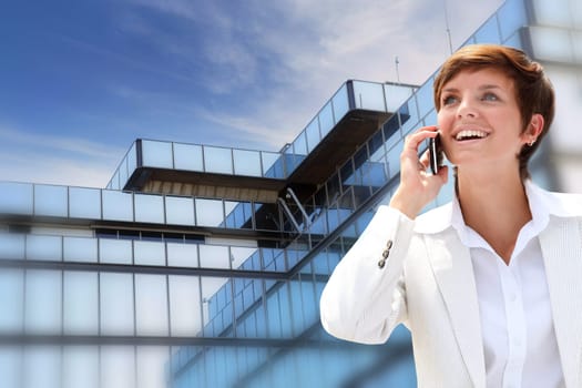 Businesswoman on the phone in front of building