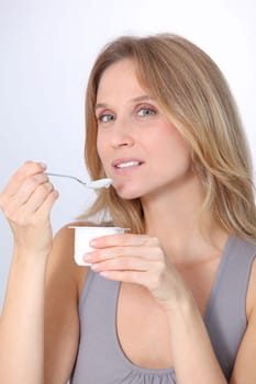 Closeup of beautiful woman eating yogurt