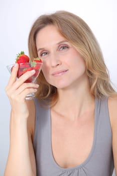 Beautiful blond woman eating strawberries