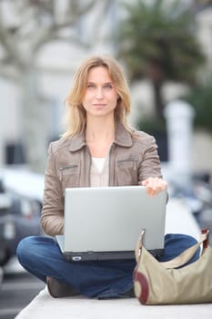Woman using laptop computer in town