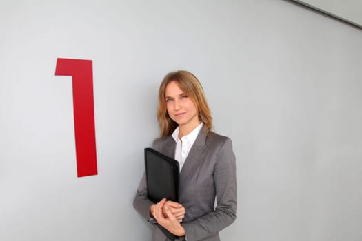 Businesswoman standing in hall against wall