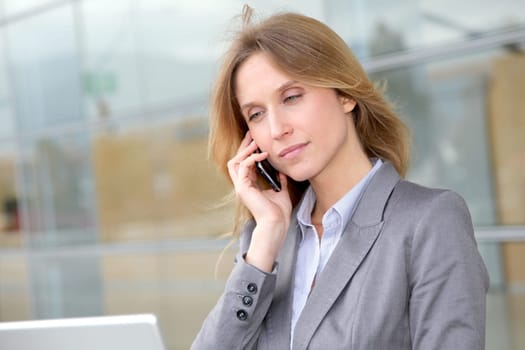 Businesswoman on the phone in front of modern building