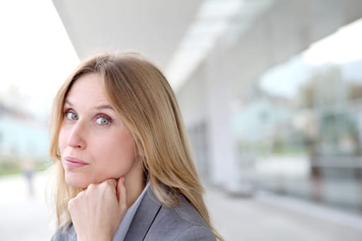 Closeup of blond businesswoman standing outside