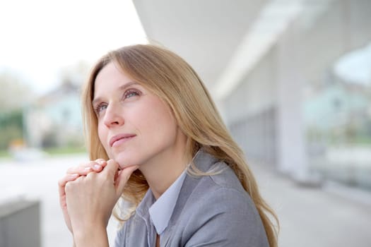 Closeup of blond businesswoman standing outside