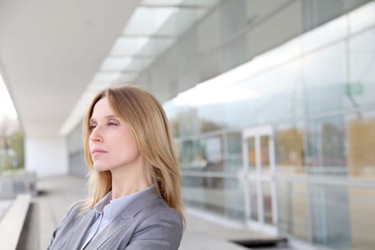 Closeup of blond businesswoman standing outside