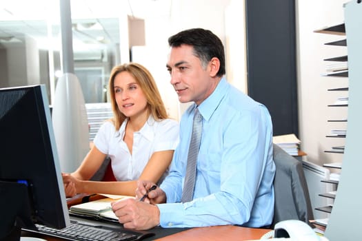 Manager and employee in front of computer in the office