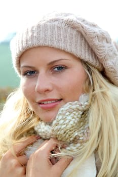 Blond woman wearing wool cap in autumn