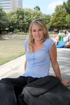Closeup of beautiful blond woman sitting in a park