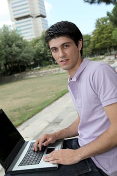 Student with laptop computer in college park