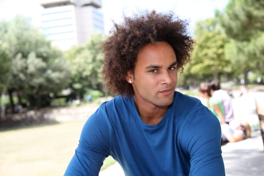 Closeup of young man sitting in a park