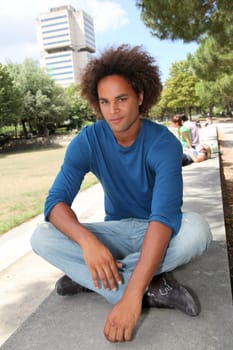 Closeup of young man sitting in a park