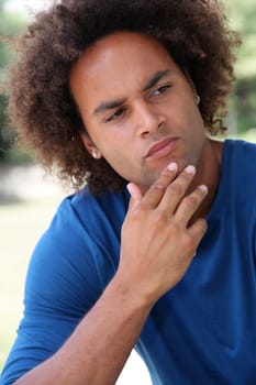 Closeup of young man thinking in a park