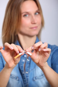 Closeup of woman breaking cigarette
