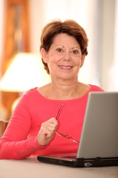 Closeup of senior woman at home with laptop computer