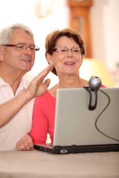 Closeup of senior couple sending messages through webcam