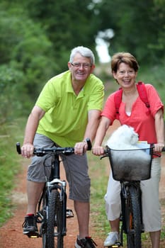 Senior couple riding bicycle in countryside