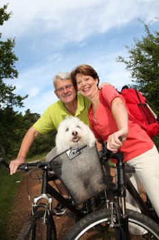 Senior couple riding bicycle in countryside