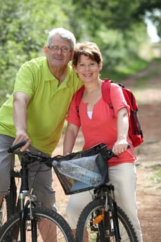 Senior couple riding bicycle in countryside