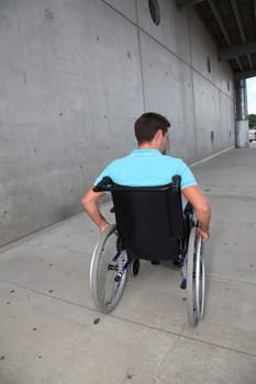 Young man using wheelchair in town