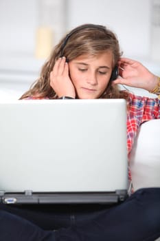 Teenager wth headphones and laptop computer