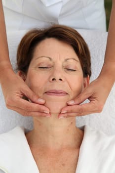 Senior woman having a face massage