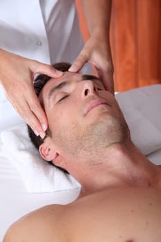 Man having a facial massage in spa center