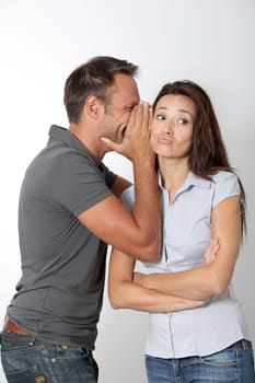Man whispering to his girlfriend ear