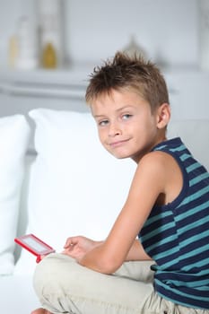 Little boy playing video games on sofa