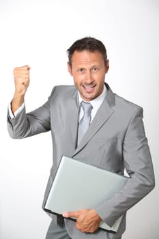 Businessman with laptop computer lifting arm up