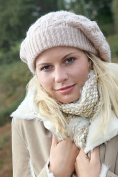 Blond woman wearing wool cap in autumn