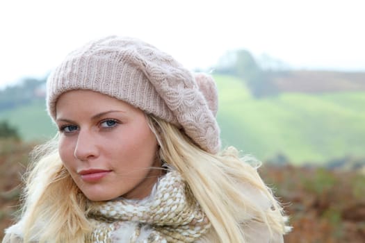 Blond woman wearing wool cap in autumn