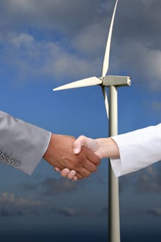 Business hanshake in front of wind turbine